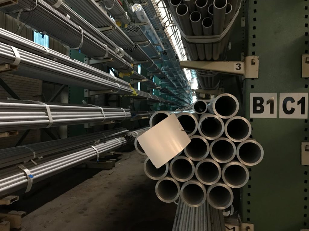The Art of Drawing Readers In: Your attractive post title goes here Rows of steel tubes stacked in an industrial warehouse, showcasing organized storage.